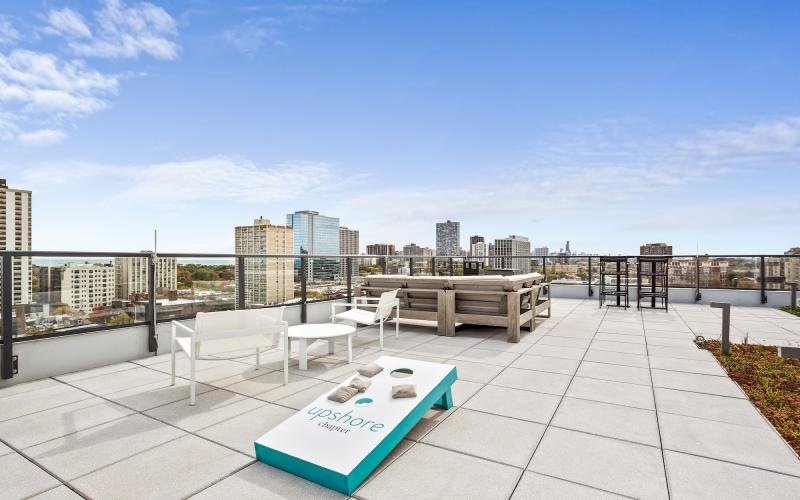 a group of tables and chairs on a rooftop overlooking a city